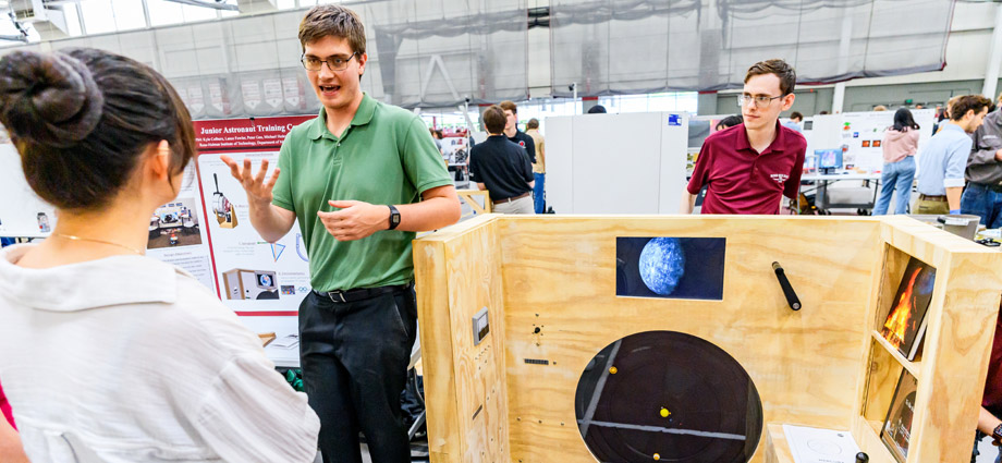A student demonstrates the wooden astronaut educational module.