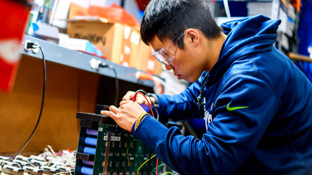 A GPE team member working on electronic components in the Branam Innovation Center.
