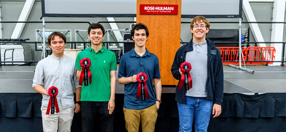 Four students hold red award ribbons.