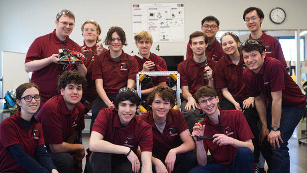 MATE Robotics team posing with their robots.
