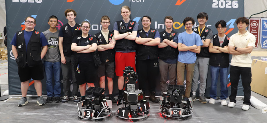 Thornbots team stands with arms crossed behind their three robots.