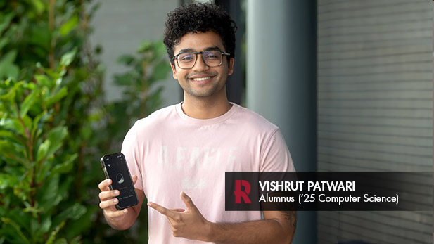 Vishrut Patwari, a 2025 computer science alumnus, points to his app on his phone.
