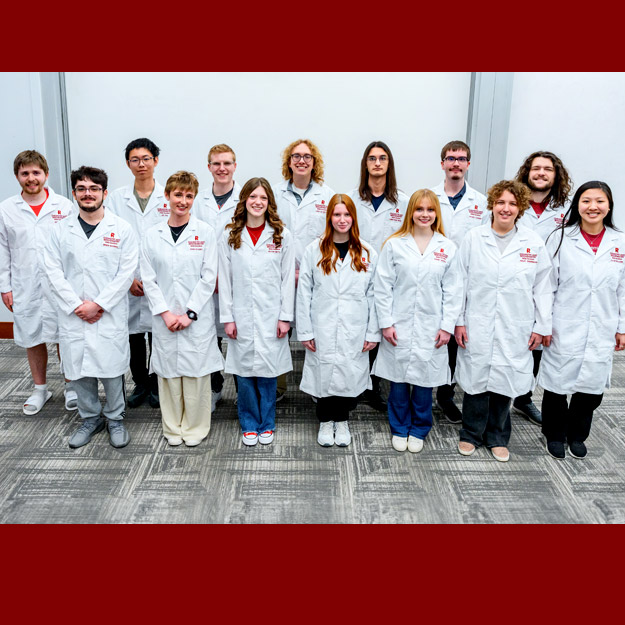 Rose-Hulman students wearing white lab coats with their names and the Rose-Hulman logo embroidered. 